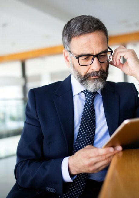 Senior business man using a digital tablet at office